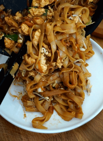 verser le pad thai dans des assiettes